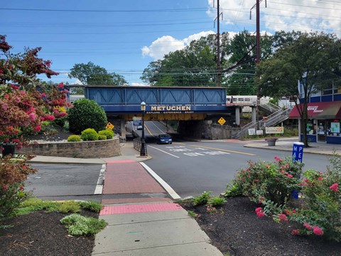 A blue bridge with the word "Metro" on it spans over a street.