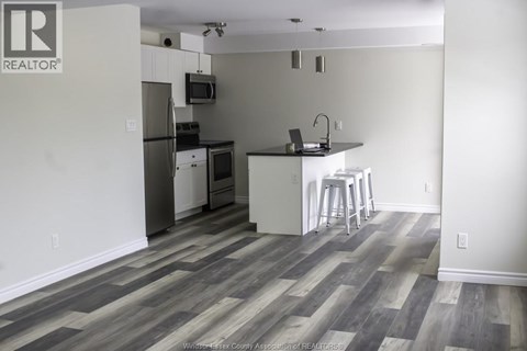 A kitchen with a refrigerator, microwave, and stove.