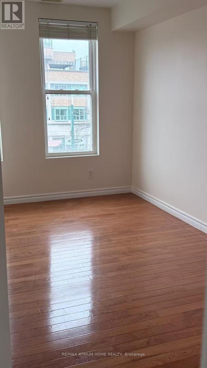 A room with a window and wooden flooring.