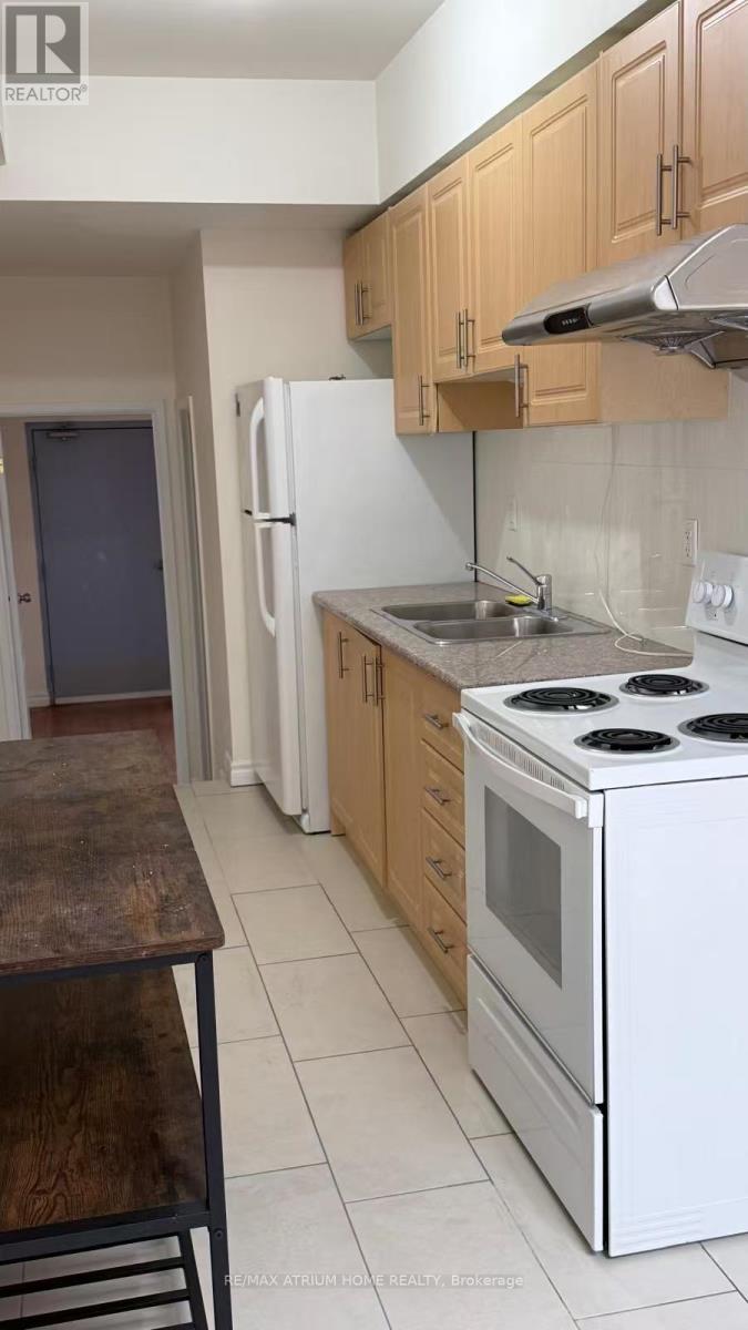 A kitchen with a white stove and wooden cabinets.