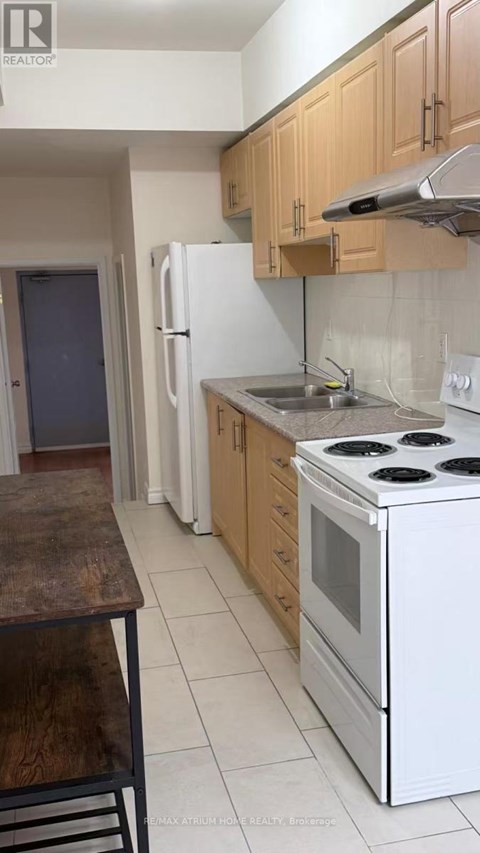 A kitchen with a white stove and wooden cabinets.