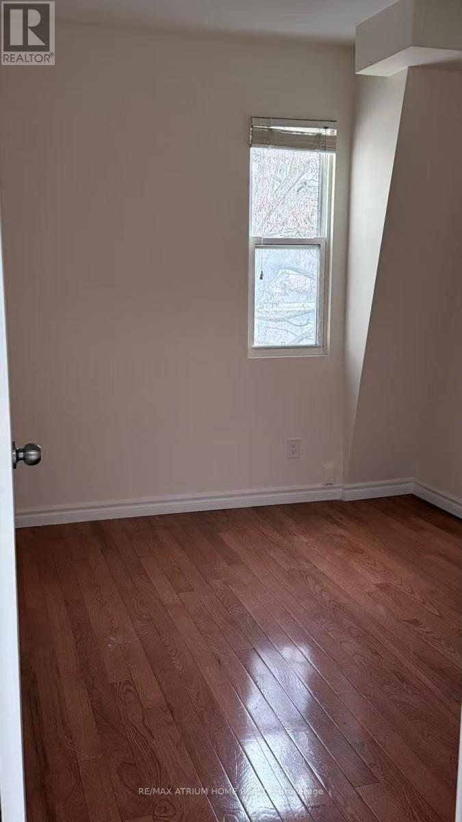 A room with a window and wooden floors.