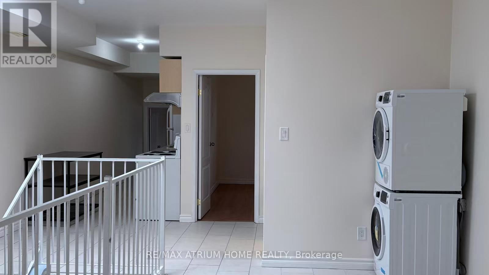 A laundry room with a washer and dryer stacked on top of each other.
