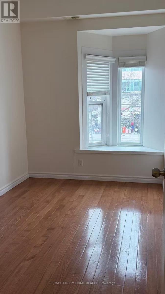 A room with a window and wooden flooring.
