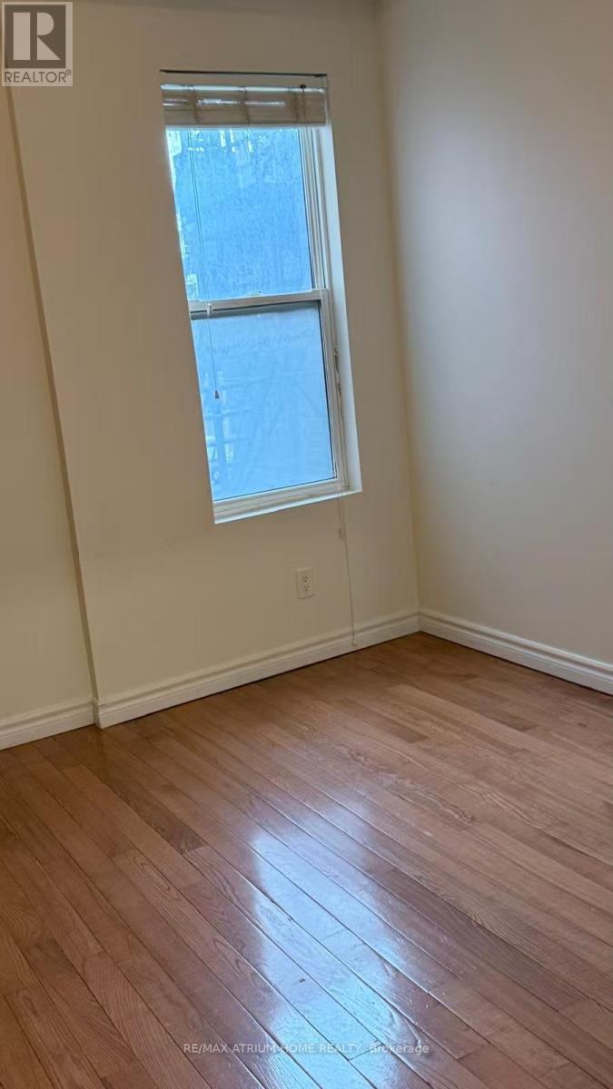 A room with a window and wooden flooring.