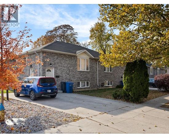 A house with a blue car parked in front.