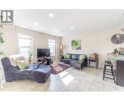 A living room with a grey couch and a black chair.