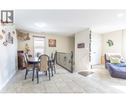 A dining room with a table set for six with chairs around it.