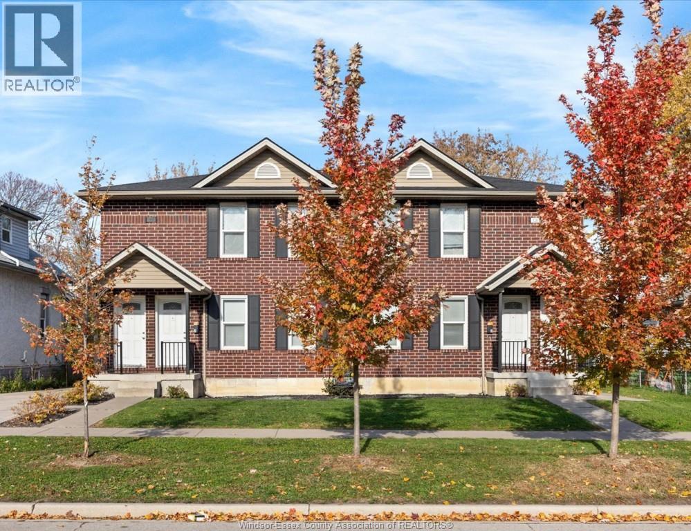 A house with a lawn and trees in front of it.