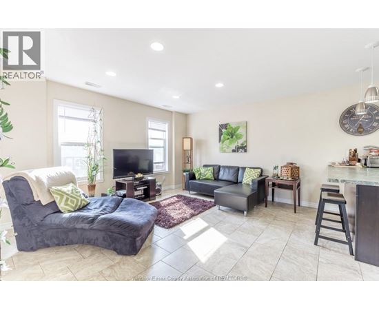 A living room with a grey couch and a black chair.
