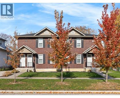 A house with a lawn and trees in front of it.
