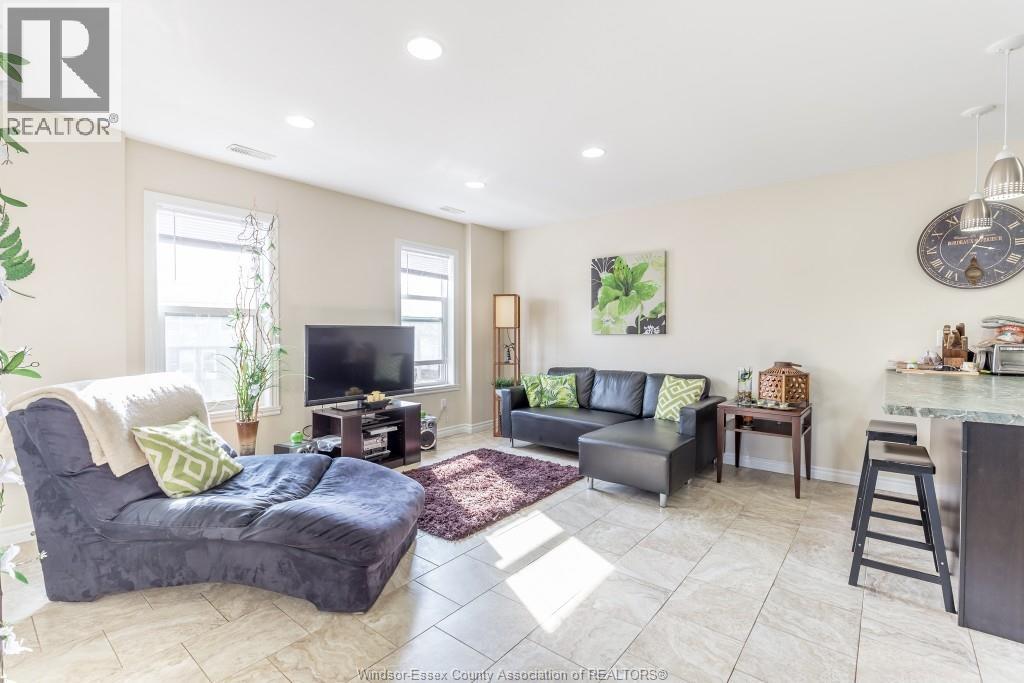 A living room with a grey couch and a black chair.