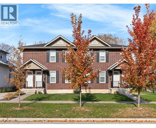 A house with a lawn and trees in front of it.