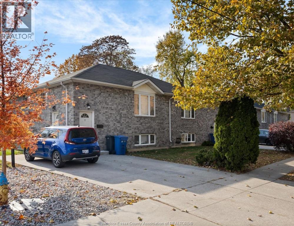 A house with a blue car parked in front.