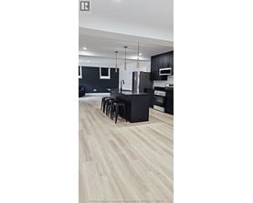 A kitchen with black cabinets and a white refrigerator.