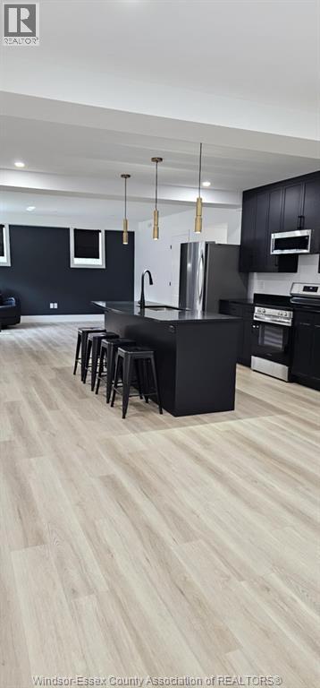 A kitchen with black cabinets and a white refrigerator.
