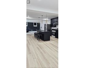 A kitchen with black cabinets and a white refrigerator.