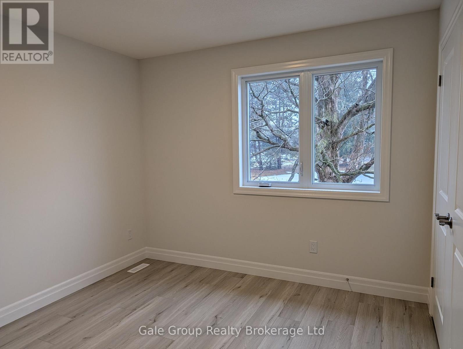 A room with a window showing trees outside.