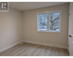 A room with a window showing trees outside.