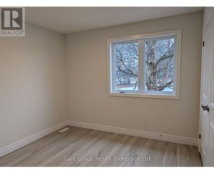 A room with a window showing trees outside.