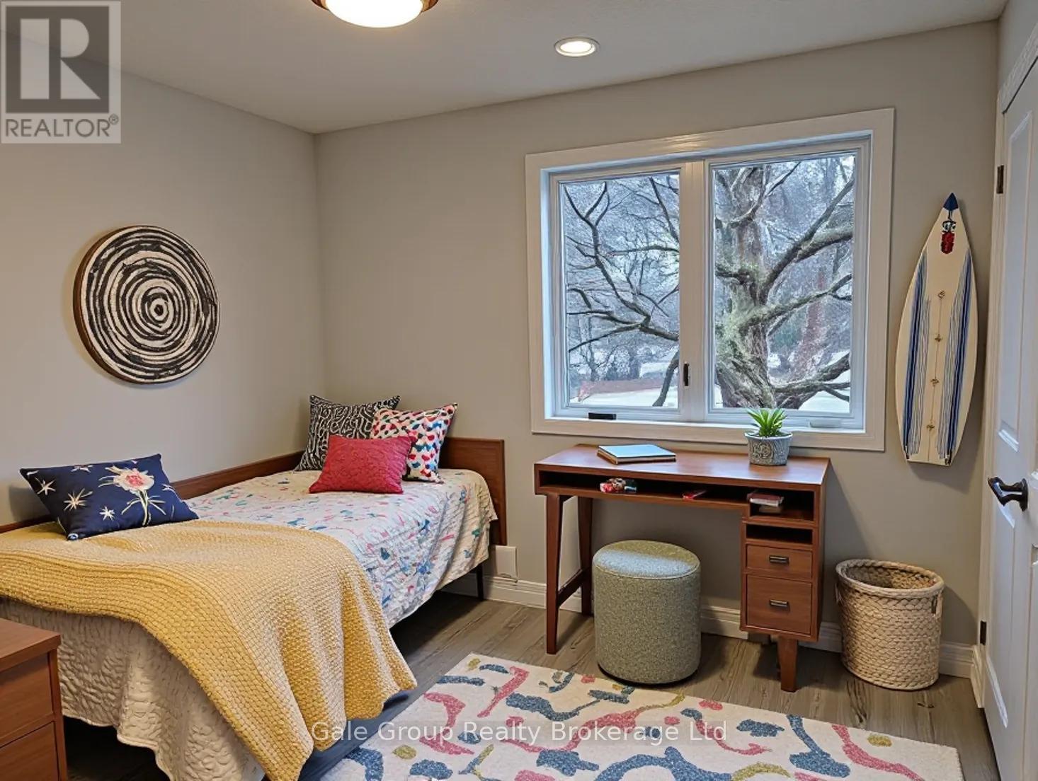 A bedroom with a bed, desk, and window.