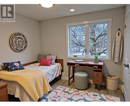 A bedroom with a bed, desk, and window.