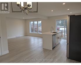 A spacious kitchen with a refrigerator, sink, and cabinets.