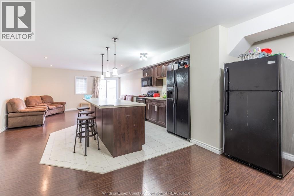 A kitchen with a bar and a refrigerator.