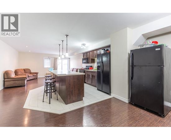 A kitchen with a bar and a refrigerator.