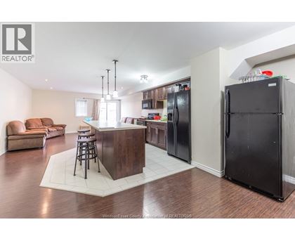 A kitchen with a bar and a refrigerator.