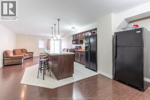 A kitchen with a bar and a refrigerator.