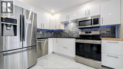 A kitchen with white cabinets and stainless steel appliances.