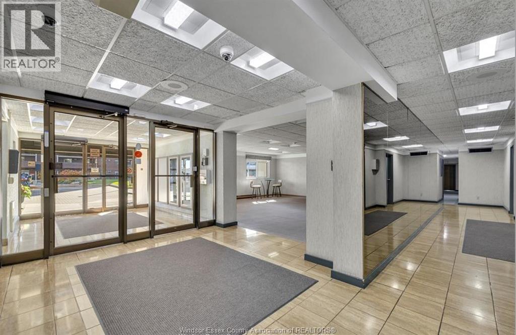 A spacious office lobby with a glass door entrance and a REALTOR sign on the wall.