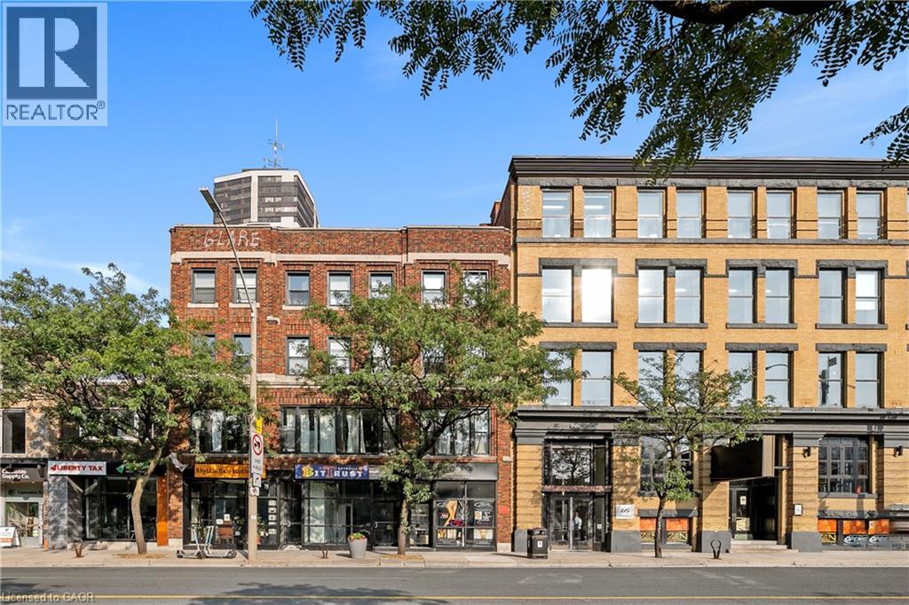 A street view of a city with buildings and a REALTOR® logo.