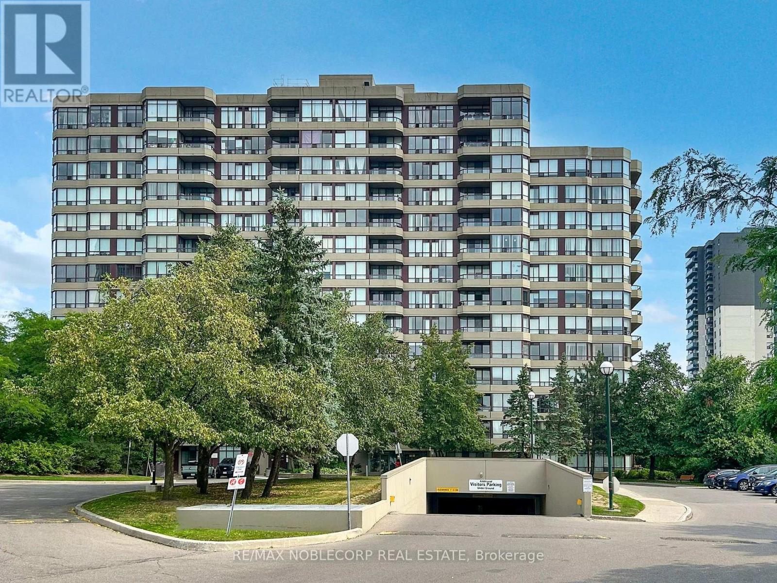 A large apartment building with a parking lot in front.