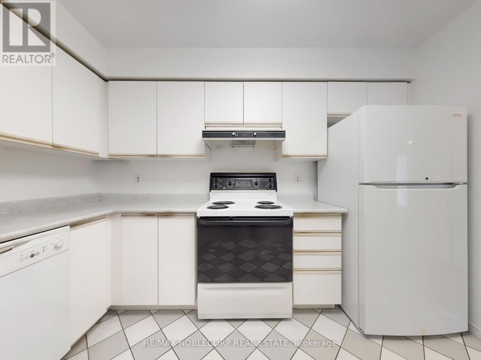 A white kitchen with a black stove top oven.
