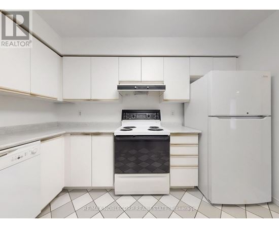 A white kitchen with a black stove top oven.