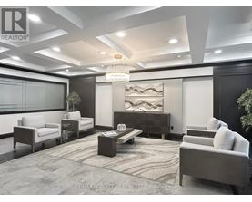 A modern living room with a large chandelier and a dark wood entertainment center.