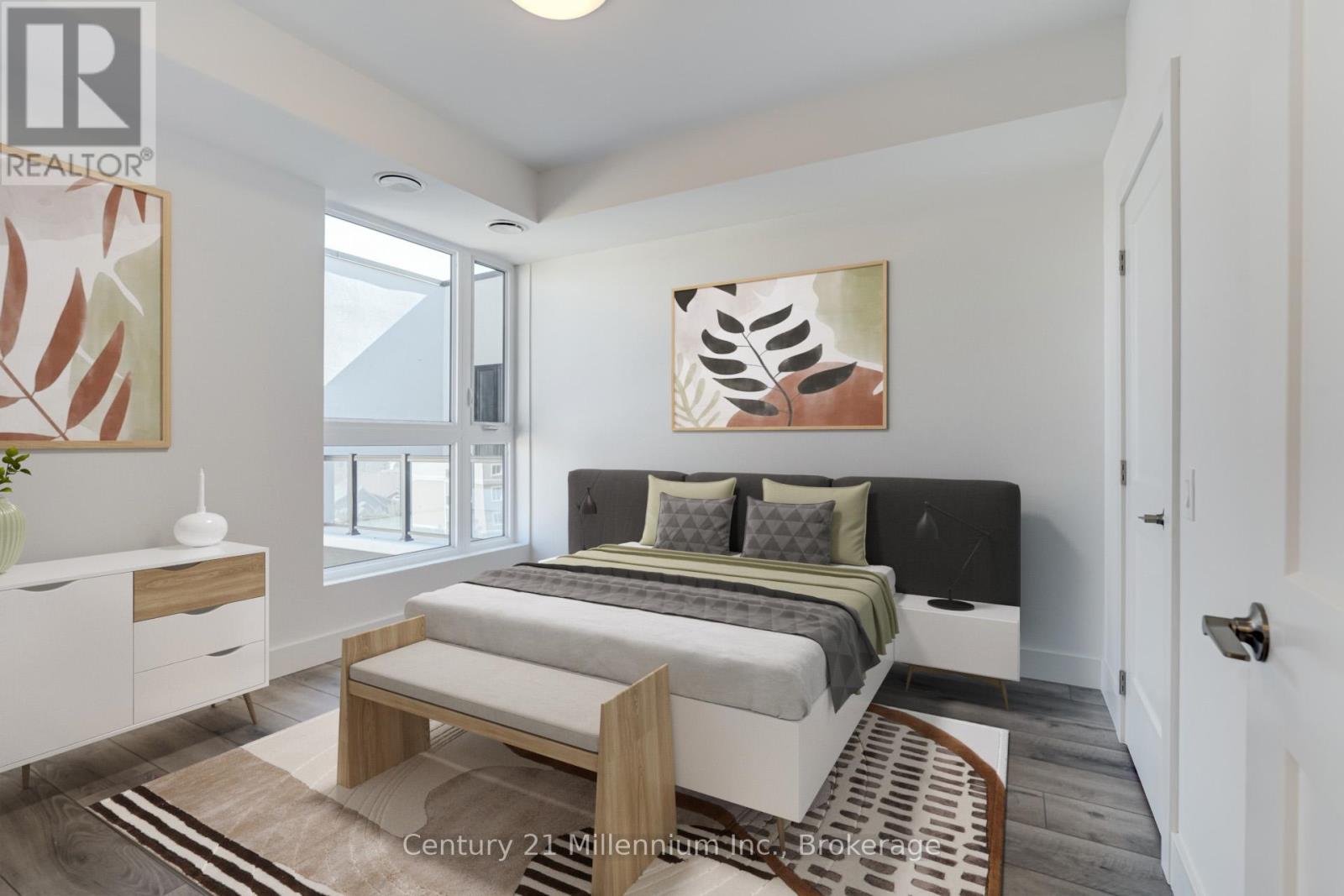 A bedroom with a bed, nightstand, and artwork on the wall.