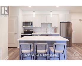 A kitchen with white cabinets and a white island with two chairs.