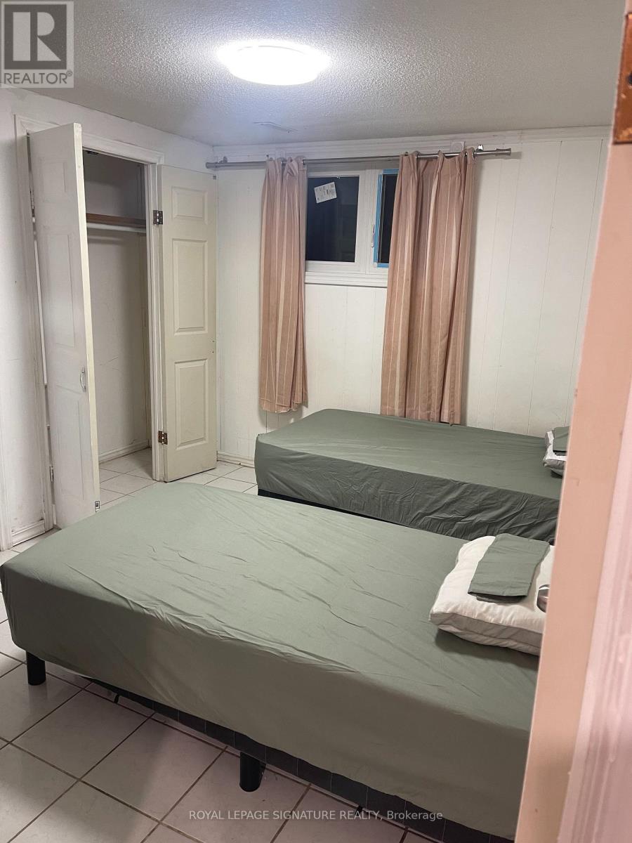 A bedroom with two beds and a window with curtains.