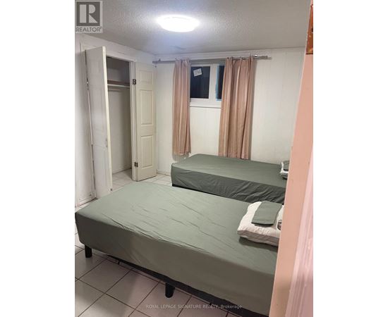 A bedroom with two beds and a window with curtains.