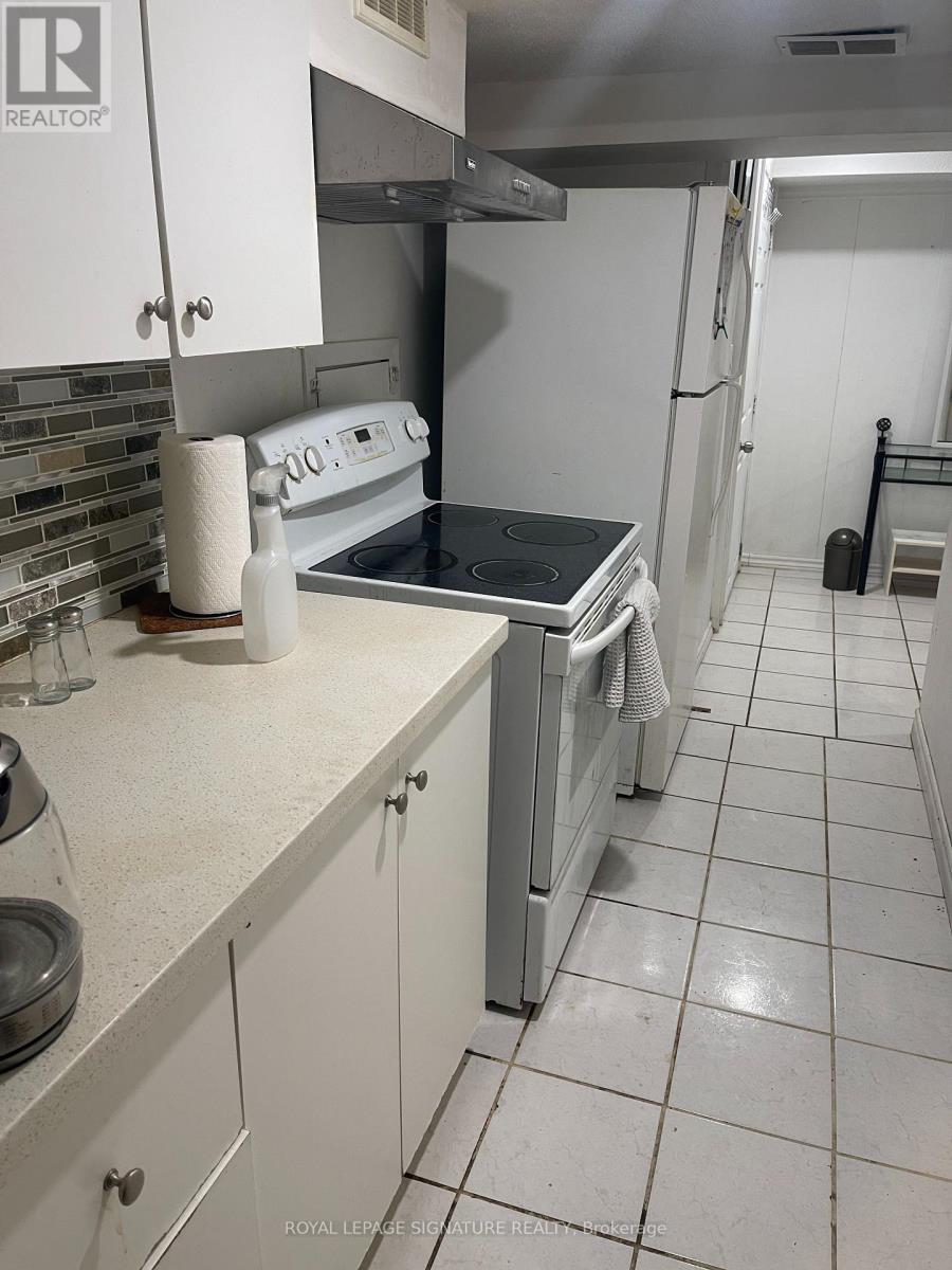 A kitchen with white cabinets and a white refrigerator.