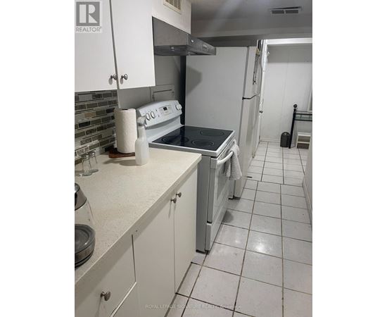 A kitchen with white cabinets and a white refrigerator.