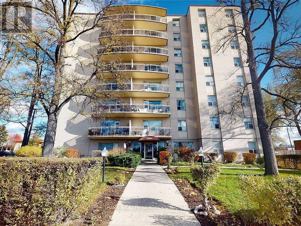 A tall apartment building with a walkway in front of it.