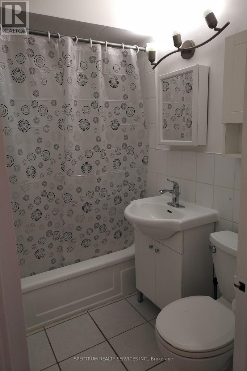 A bathroom with a shower curtain, toilet, and sink.