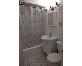 A bathroom with a shower curtain, toilet, and sink.