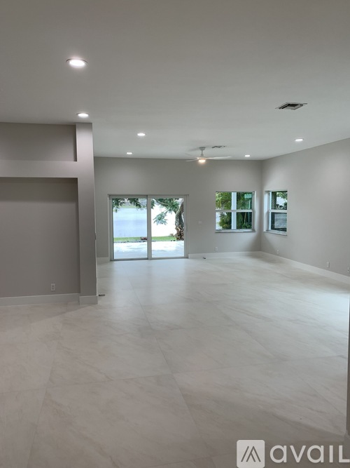 A spacious room with a sliding glass door leading outside.