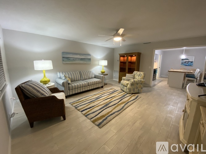 A living room with a striped couch and a wooden chair.