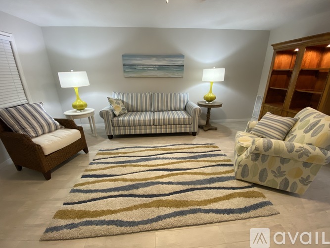 A living room with a striped rug and a striped couch.